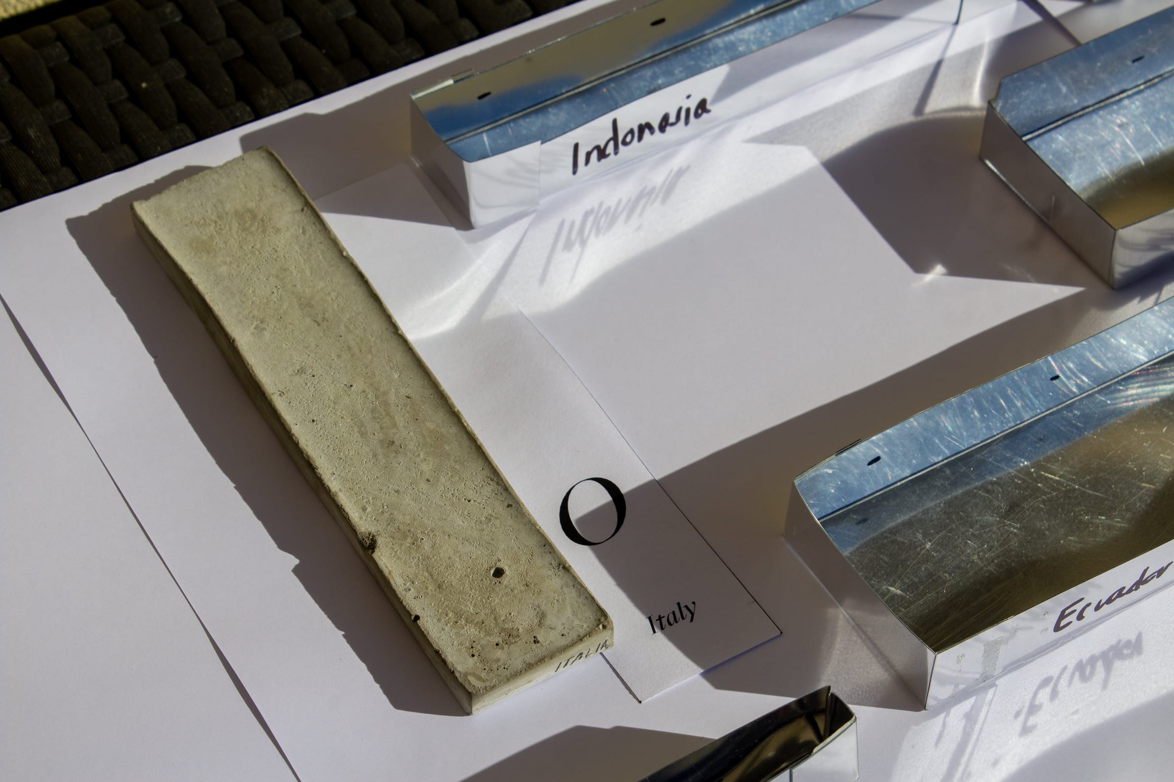 A concrete test bar beside the metal moulds