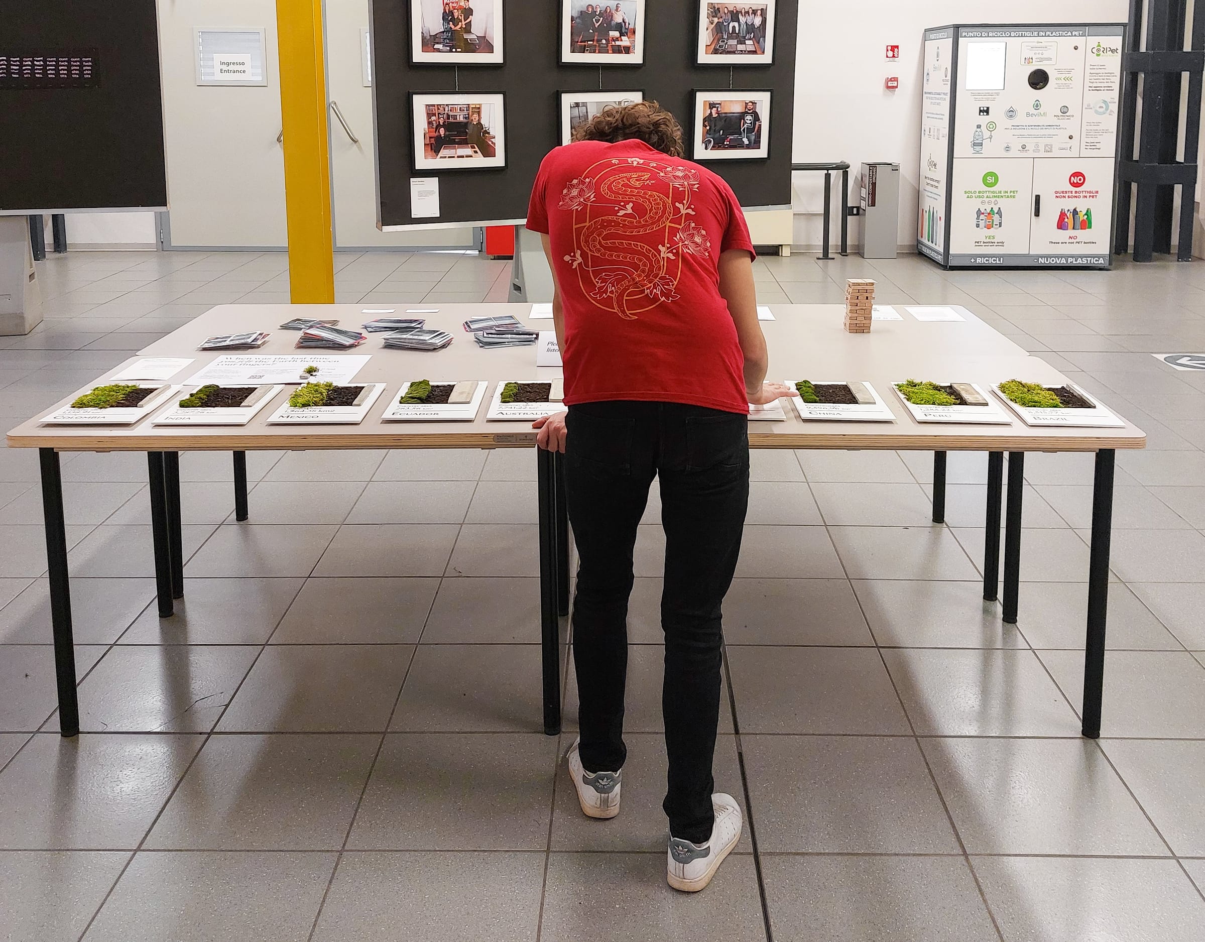 A visitor leans over the table of ten boards to touch them